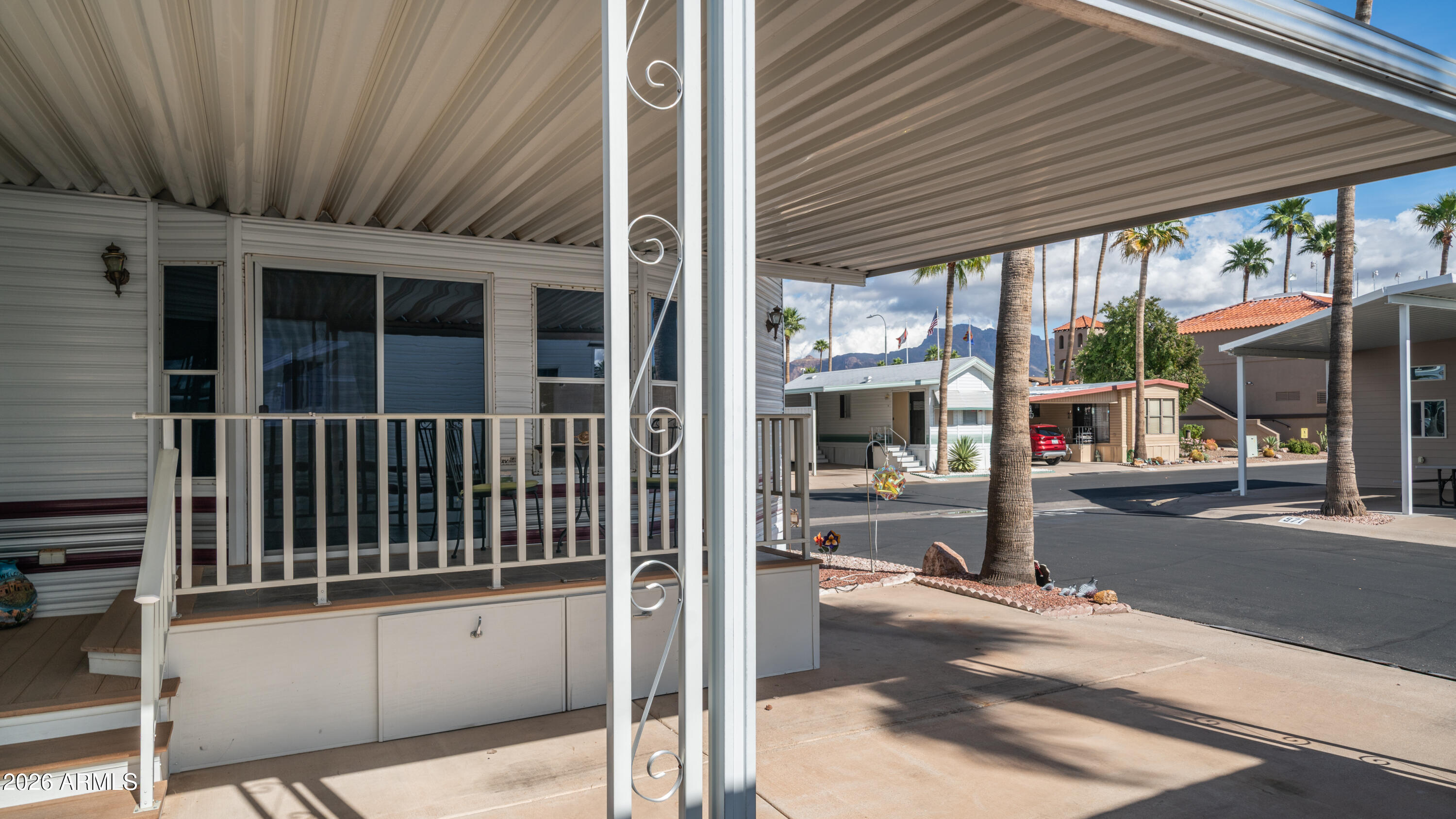3710 South Goldfield Road, Unit 972 Apache Junction, AZ 85119 - Photo 9 of 60 a view of a porch with a table and chairs