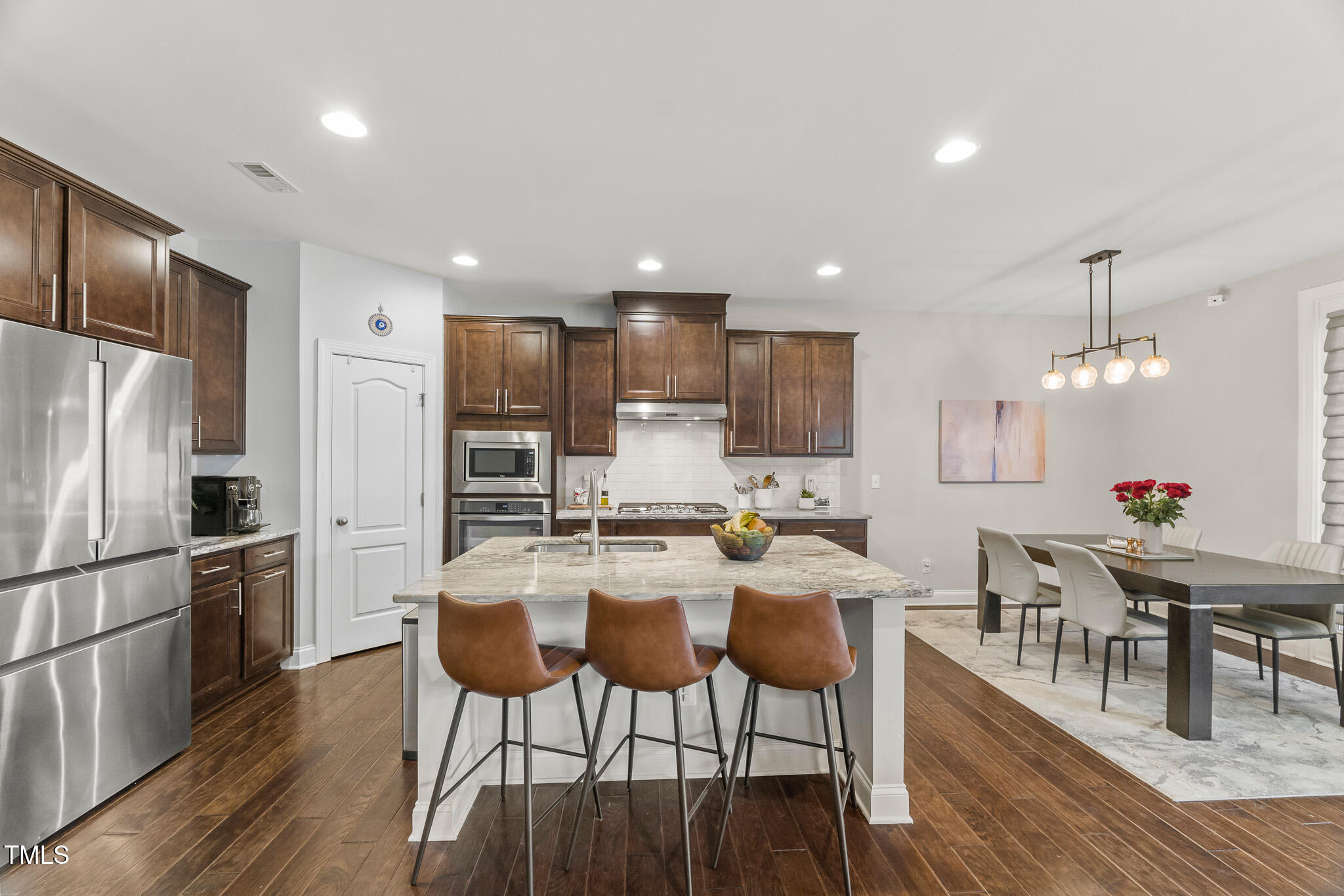1715 Capstone Drive Durham, NC 27713 - Photo 7 of 53 a kitchen with stainless steel appliances kitchen island granite countertop a kitchen island a stove a table and chairs