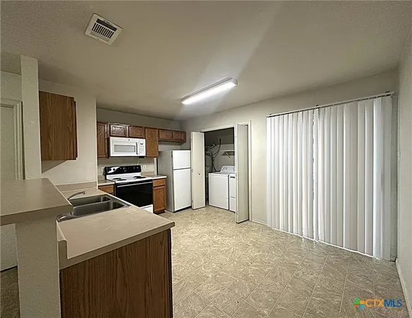 a kitchen with a refrigerator and a stove top oven
