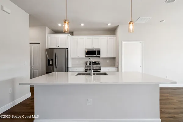 a kitchen with refrigerator and microwave