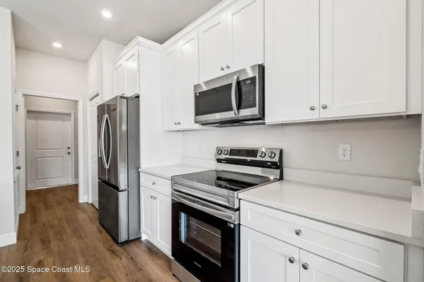 a kitchen with stainless steel appliances a stove microwave and a refrigerator