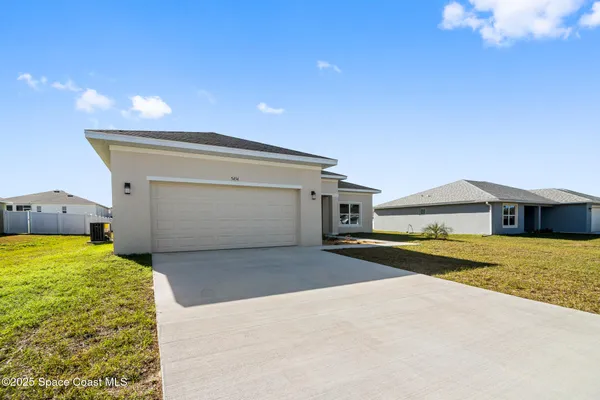 a view of a house with a yard and a garage