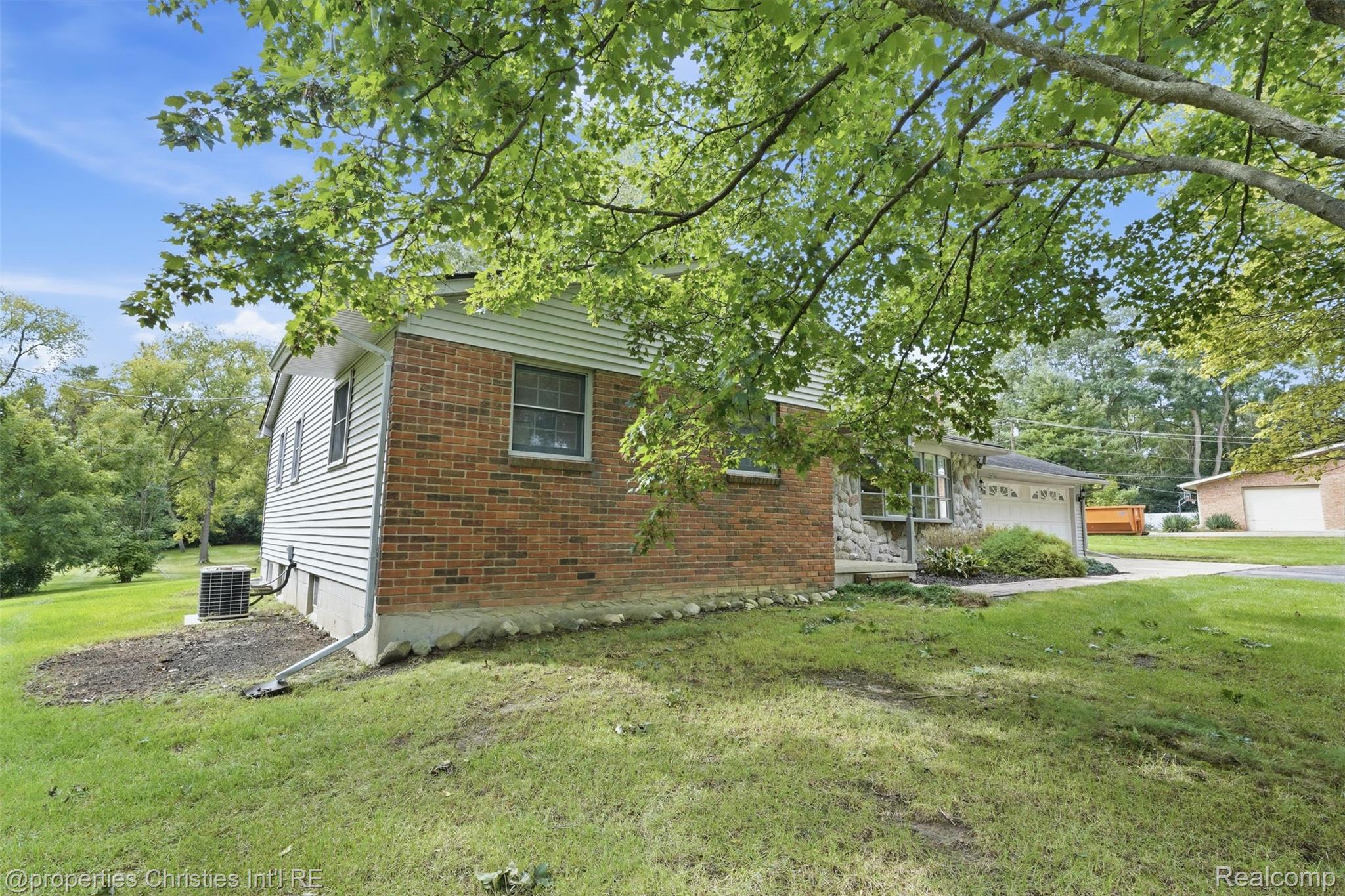 4030 Textile Road Ypsilanti, MI 48197 - Photo 3 of 58 Brick and siding exterior featuring an attached garage and mature trees