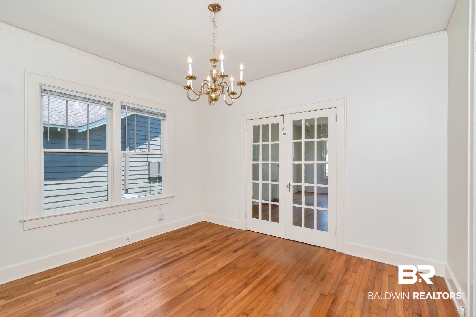 112 South Fulton Street Mobile, AL 36606 - Photo 12 of 35 Unfurnished room with french doors, an inviting chandelier, and hardwood / wood-style flooring
