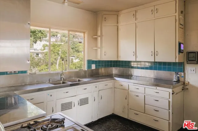 a kitchen with a sink window and cabinets