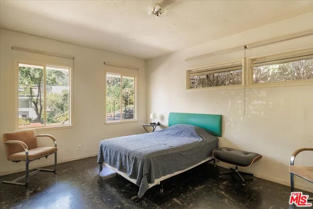 a bedroom with a bed chair and window
