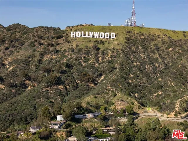 an aerial view of a house with a yard and large trees