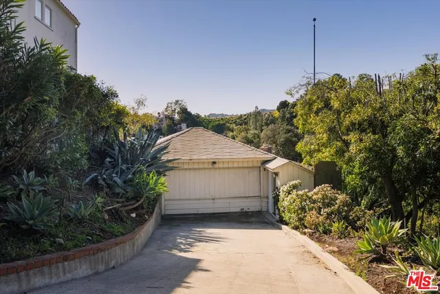 a view of a house with a yard and potted plants