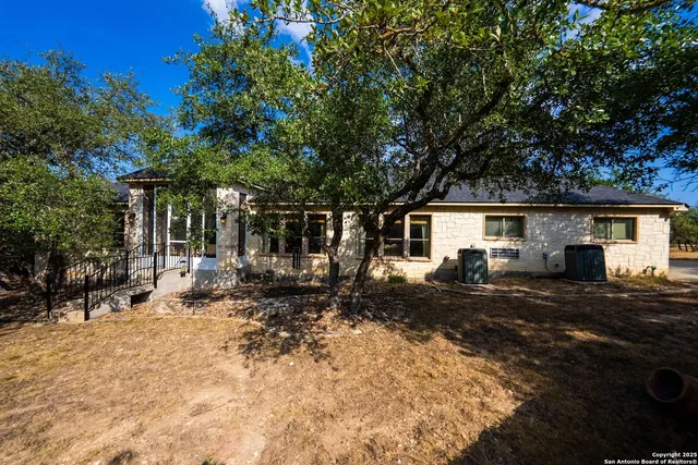 a view of swimming pool with outdoor seating and trees in the background