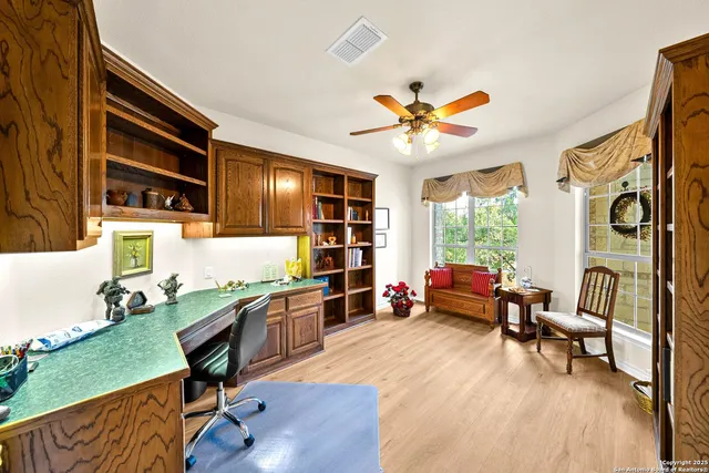 a view of a big room with wooden floor and a ceiling fan