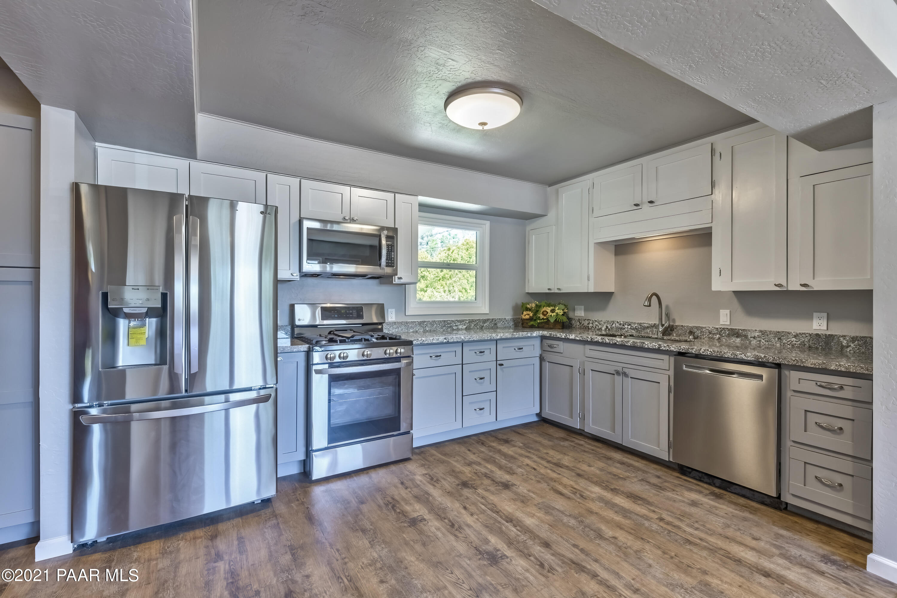 844 Flora Street Prescott, AZ 86301 - Photo 10 of 29 a kitchen with granite countertop stainless steel appliances and wooden cabinets