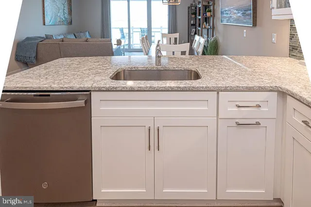 a kitchen with kitchen island granite countertop a sink and a stove top oven