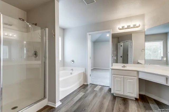 a bathroom with a tub sink and mirror