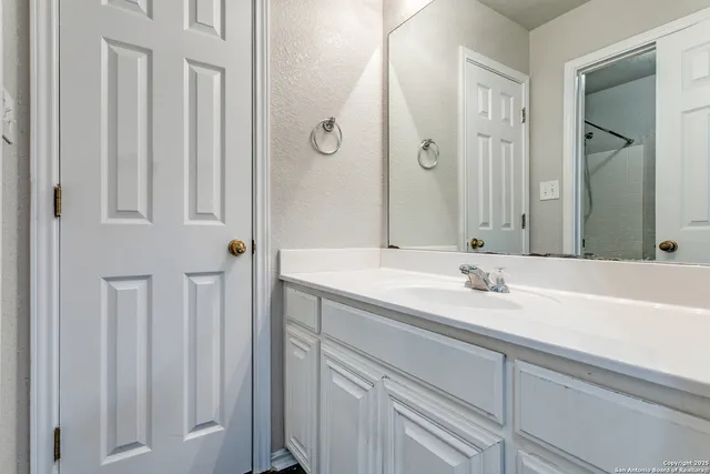 a bathroom with a granite countertop sink and a mirror
