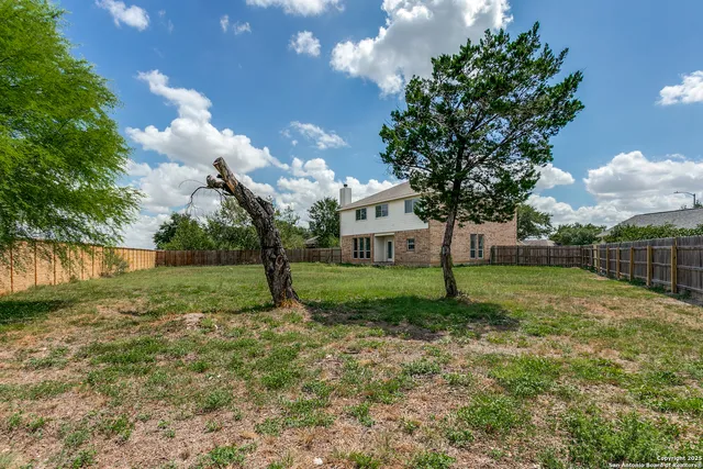 a view of a house with yard and a tree