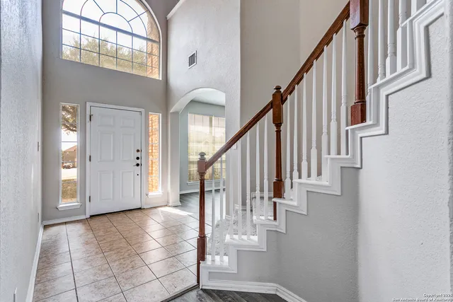 a view of staircase with lots of frames on wall and wooden floor