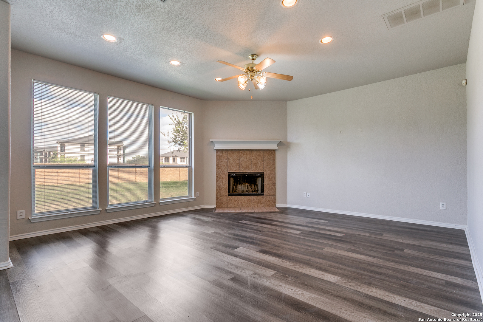 21715 Hanover Crest San Antonio, TX 78259 - Photo 8 of 25 a view of an empty room with wooden floor and a fireplace