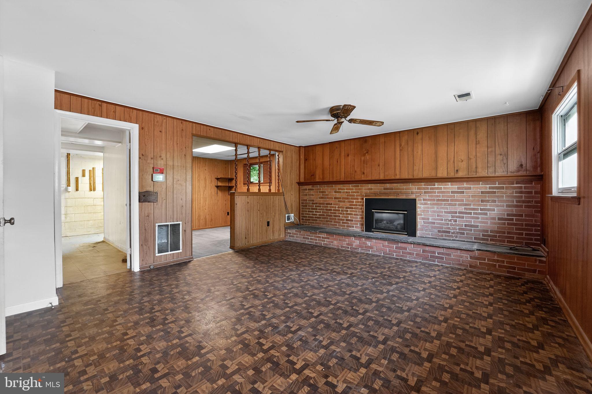 7012 Redmiles Road Laurel, MD 20707 - Photo 12 of 31 a view of empty room with a fireplace and wooden floor