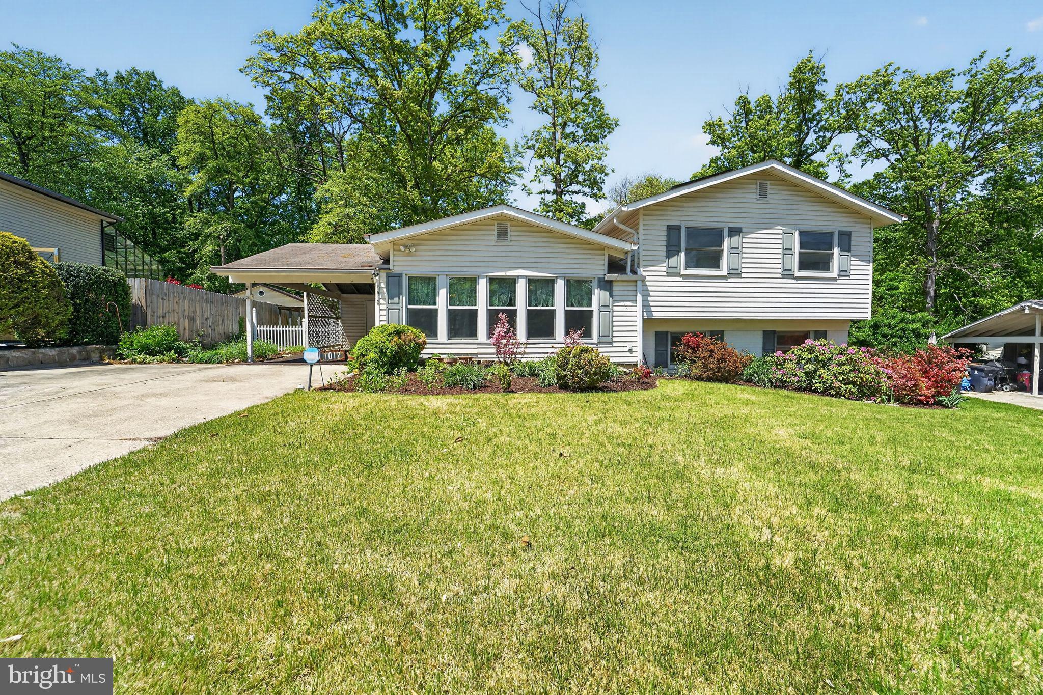 7012 Redmiles Road Laurel, MD 20707 - Photo 2 of 31 a front view of a house with a garden and trees