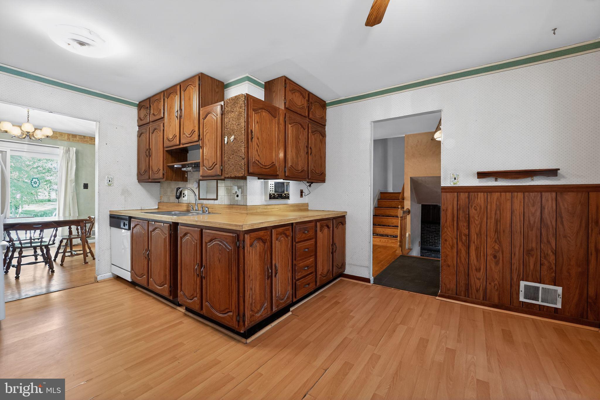 7012 Redmiles Road Laurel, MD 20707 - Photo 7 of 31 a kitchen with stainless steel appliances granite countertop a stove a sink dishwasher and a refrigerator with wooden floor