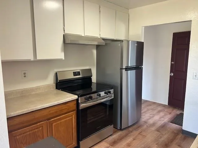 a kitchen with a refrigerator stove and cabinets