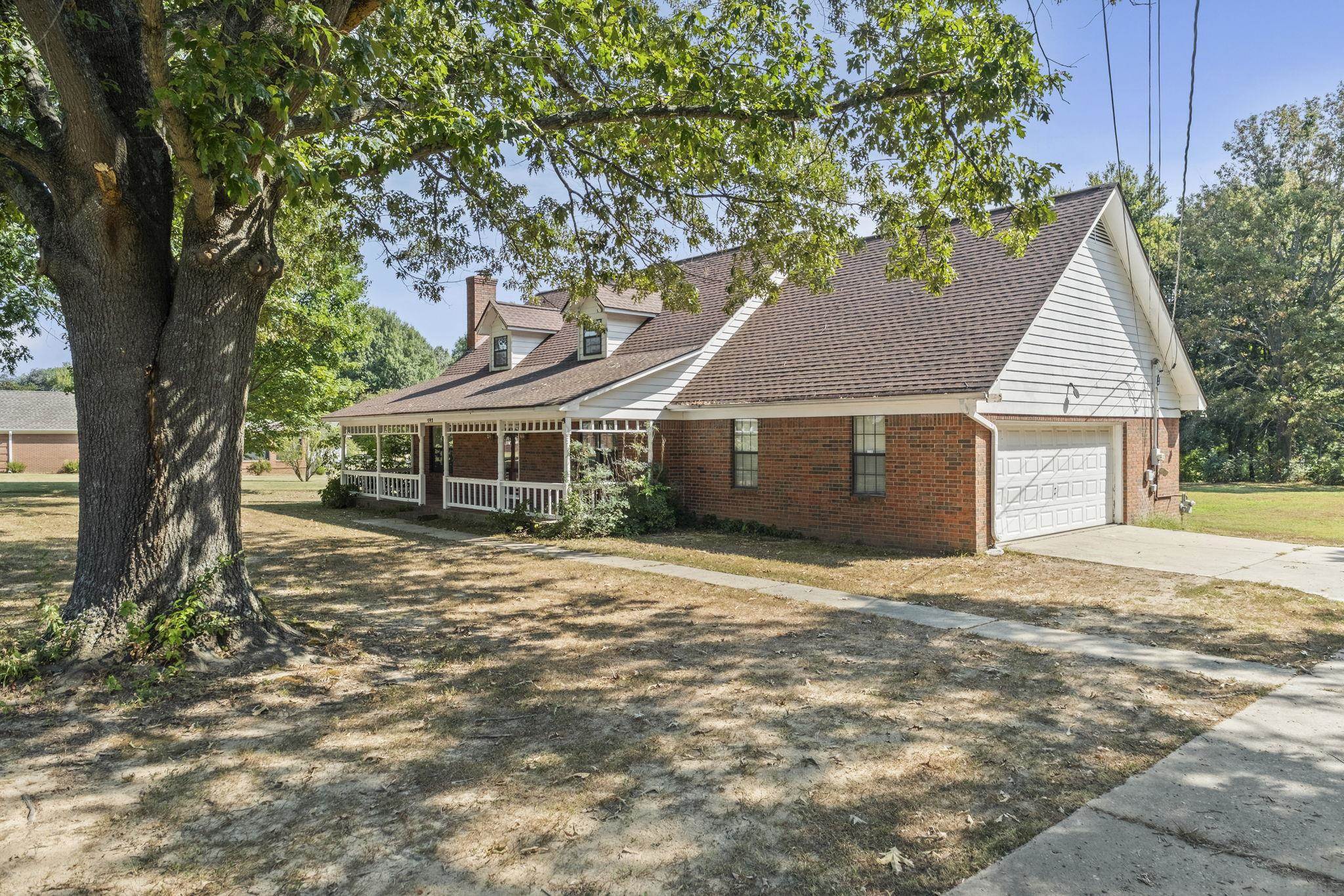 143 Ashley Lane Brighton, TN 38011 - Photo 1 of 37 View of front of house featuring brick siding, covered porch, a chimney, driveway, and a shingled roof