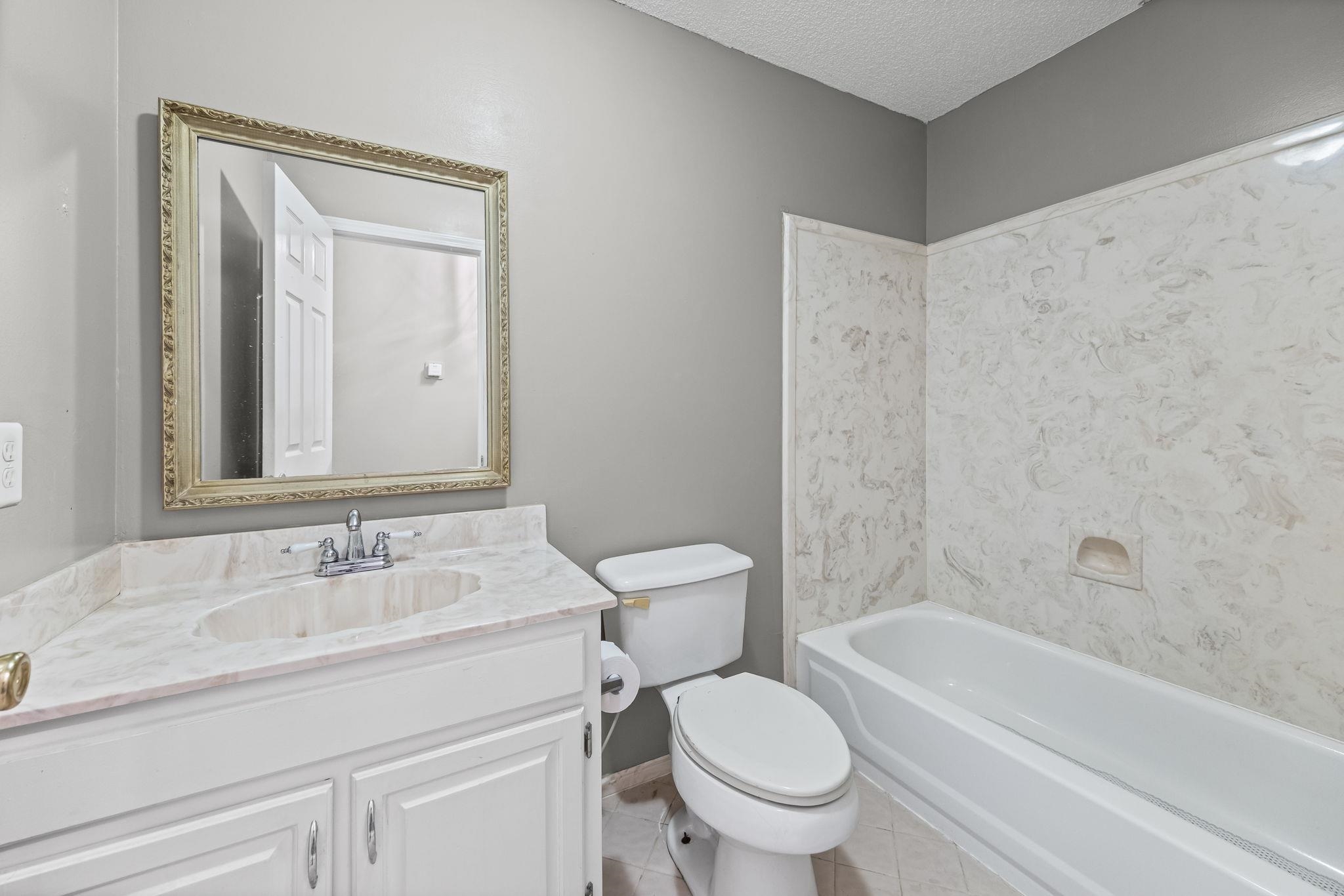 143 Ashley Lane Brighton, TN 38011 - Photo 24 of 37 Bathroom with vanity, light tile patterned floors, a textured ceiling, and shower / tub combination
