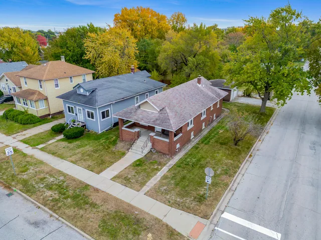 a view of a house with a small yard and a large tree