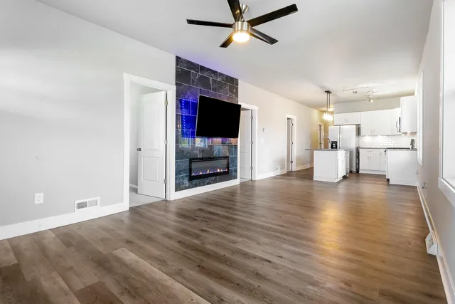 a view of a livingroom with a kitchen and a stove wooden floor