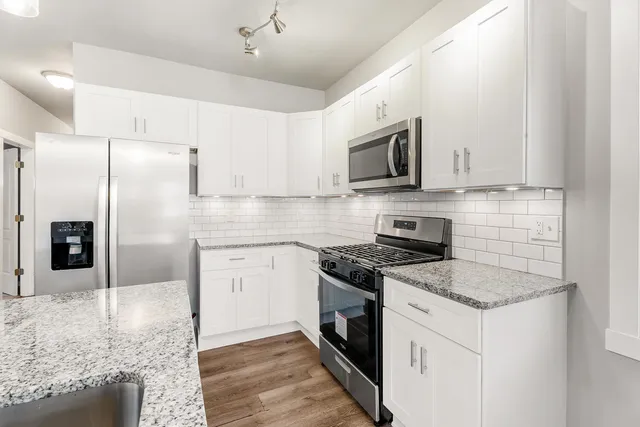 a kitchen with stainless steel appliances granite countertop a stove a refrigerator and a microwave