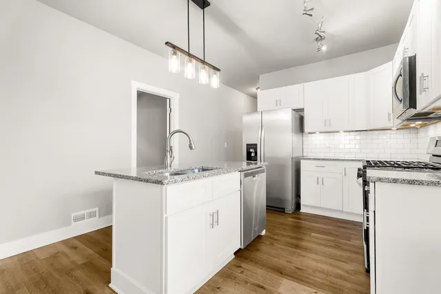 a kitchen with a sink stainless steel appliances and refrigerator