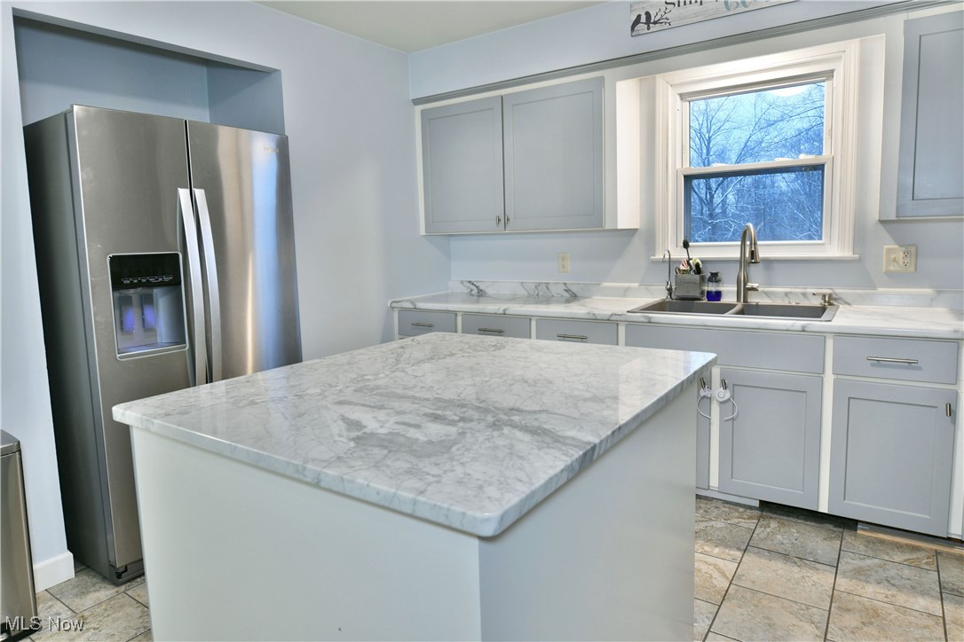 4335 Crew Hood Road Girard, OH 44420 - Photo 18 of 50 Kitchen featuring light stone counters, gray cabinetry, sink, stainless steel fridge with ice dispenser, and a kitchen island
