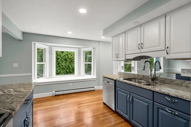 a kitchen with granite countertop wooden cabinets a sink and a window