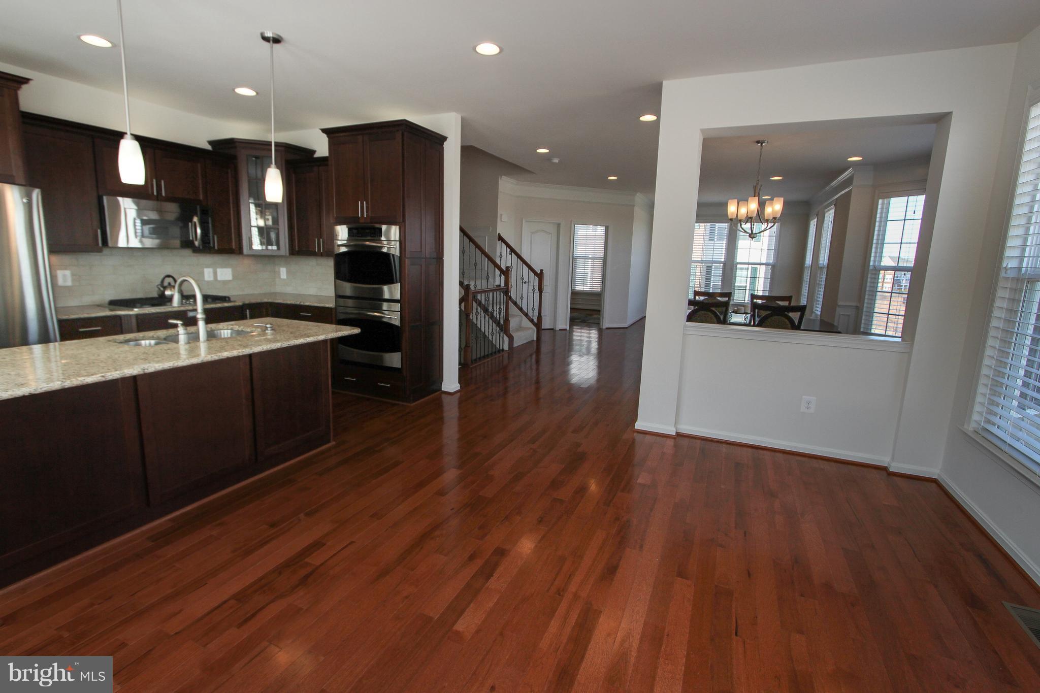 22629 Hawkbill Square Ashburn, VA 20148 - Photo 2 of 30 a kitchen with stainless steel appliances granite countertop wooden floors wooden cabinets and sink