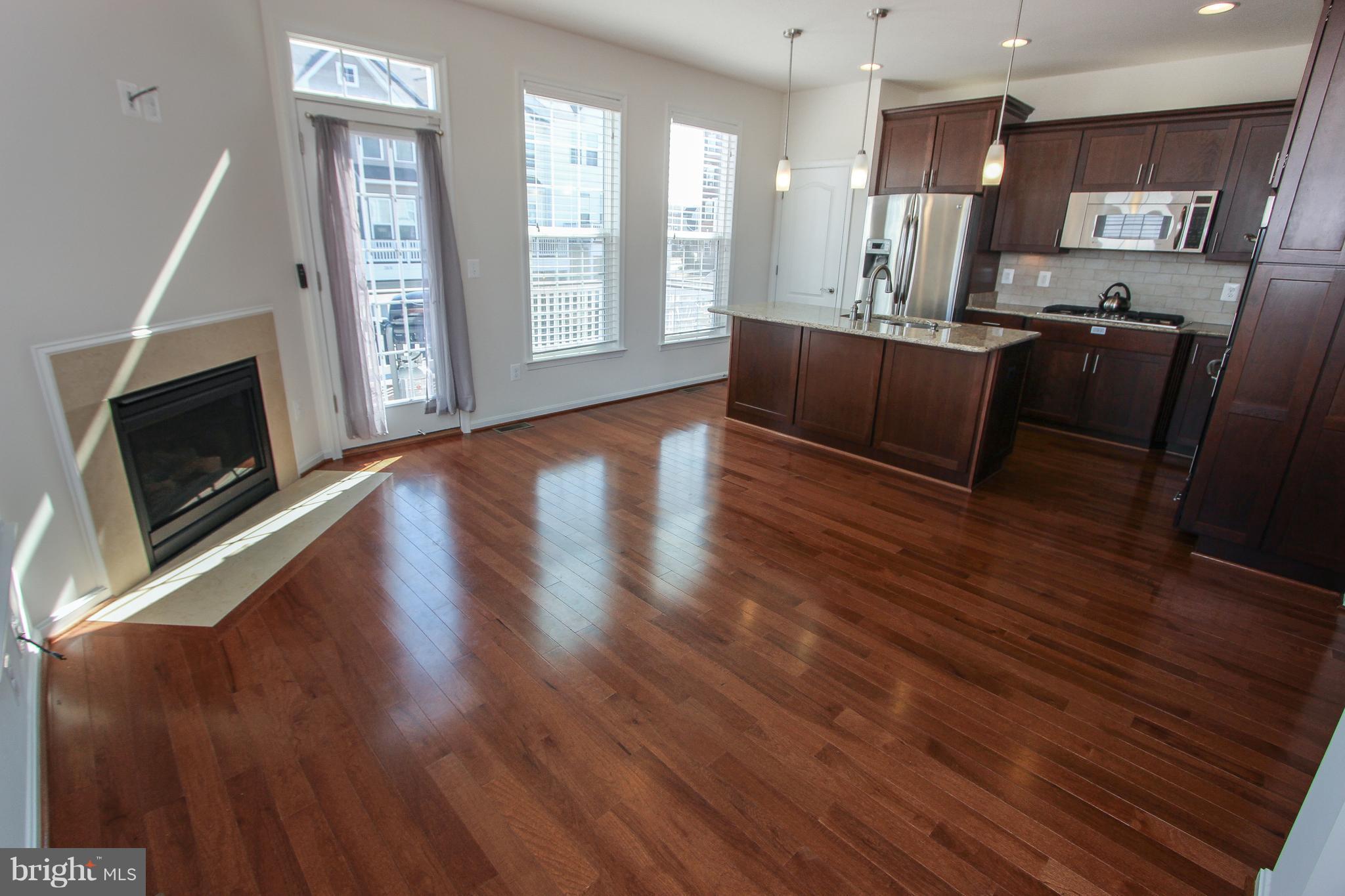 22629 Hawkbill Square Ashburn, VA 20148 - Photo 16 of 30 a large open kitchen with stainless steel appliances wooden floors and large window
