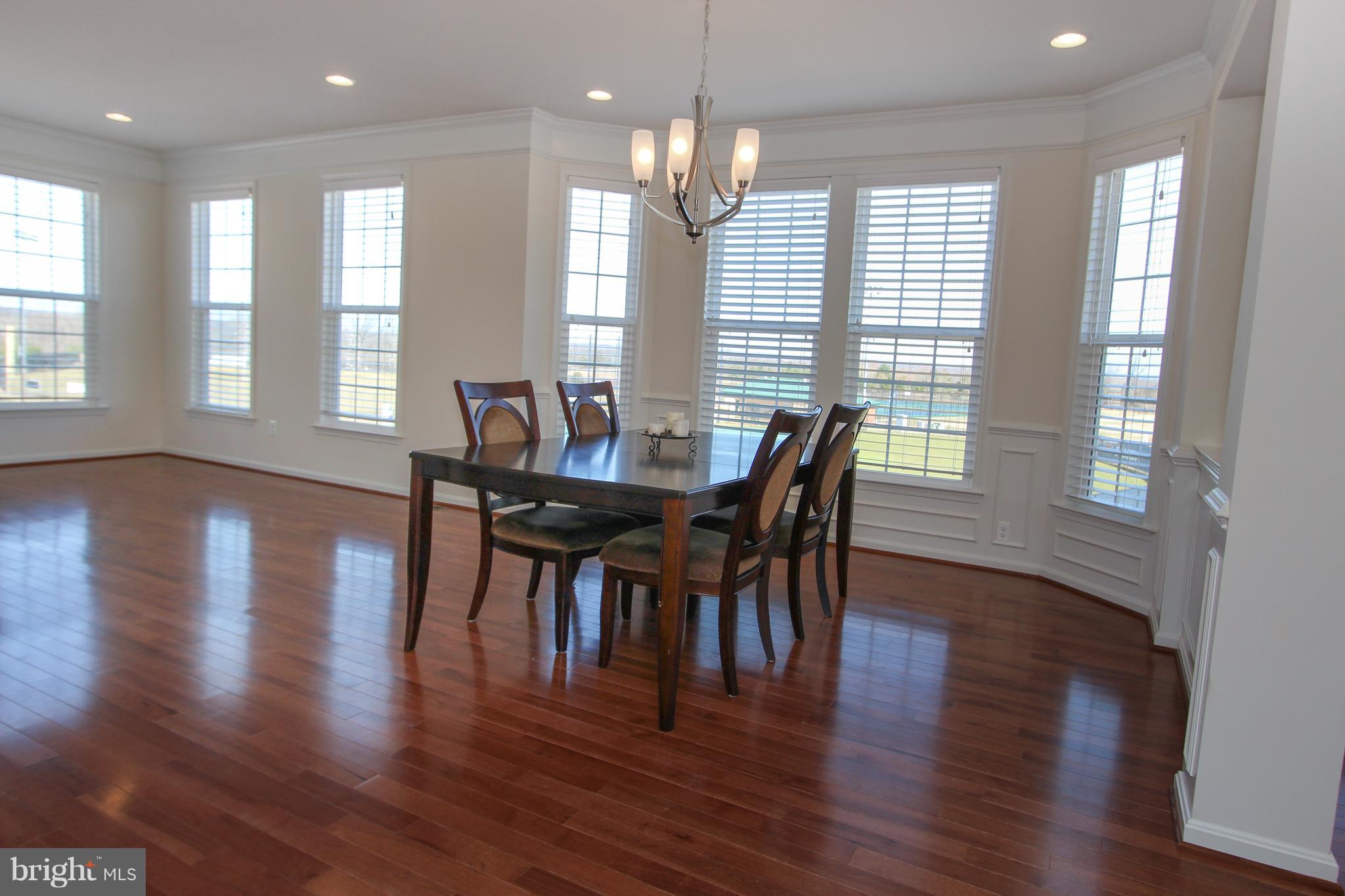 22629 Hawkbill Square Ashburn, VA 20148 - Photo 5 of 30 a dining room with wooden floor a chandelier a glass table and chairs