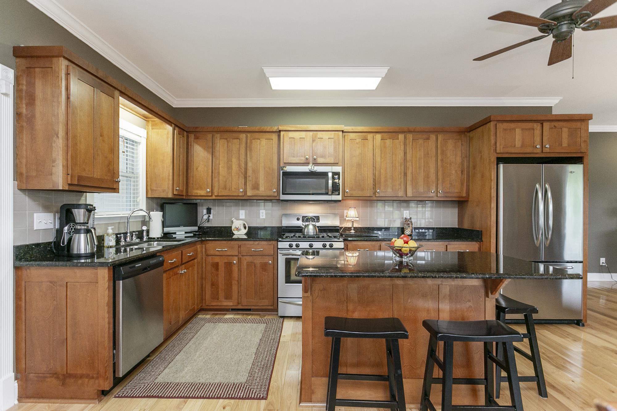 5154 Youngville Road Springfield, TN 37172 - Photo 7 of 30 a kitchen with stainless steel appliances granite countertop a stove top oven a refrigerator a sink and dishwasher with wooden floor