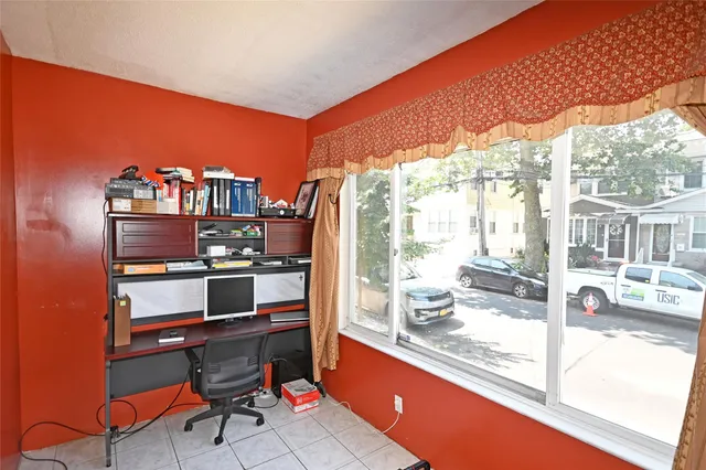a living room with furniture a flat screen tv and a floor to ceiling window