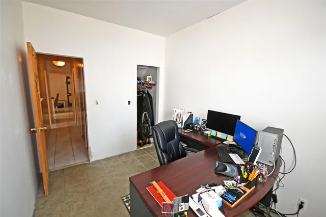 a view of a workspace with furniture and a window