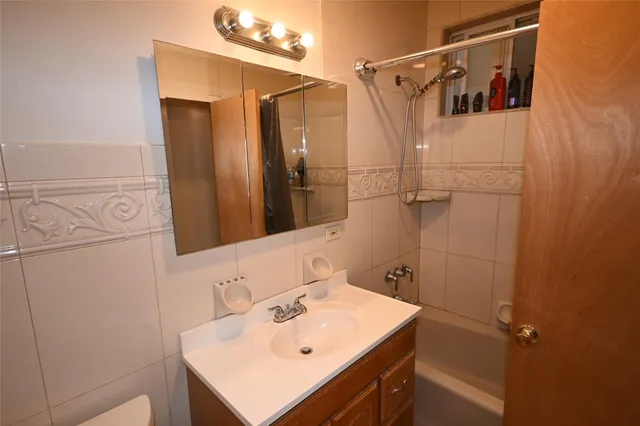 a bathroom with a sink mirror and shower