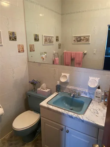 a bathroom with a sink a toilet and a mirror