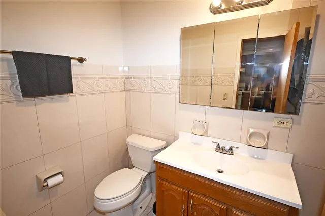 a bathroom with a toilet sink vanity and mirror