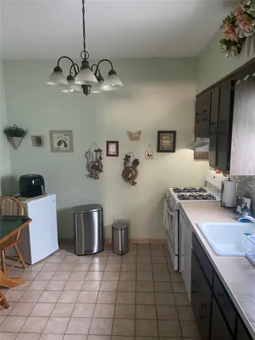 a kitchen with stainless steel appliances a stove a sink a refrigerator and microwave