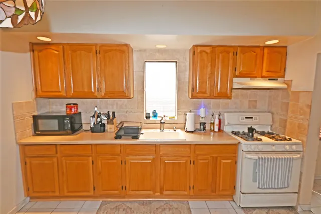 a kitchen with stainless steel appliances granite countertop a sink stove and cabinets