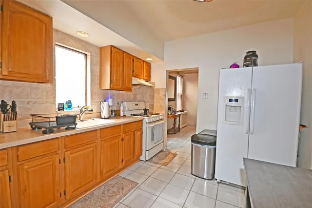 a kitchen with a sink a refrigerator and cabinets