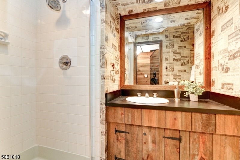 600 North Monroe Street Ridgewood, NJ 07450 - Photo 18 of 18 a bathroom with a granite countertop sink a mirror and a shower