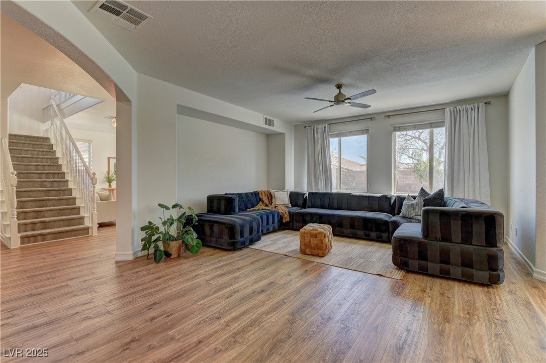 9992 South Sky Parlor Road Las Vegas, NV 89178 - Photo 12 of 42 Living area featuring stairway, visible vents, a ceiling fan, and wood finished floors