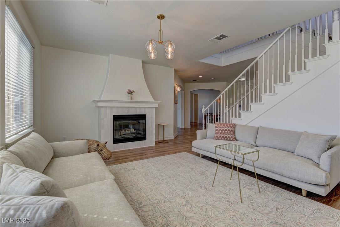 9992 South Sky Parlor Road Las Vegas, NV 89178 - Photo 16 of 42 Living room with arched walkways, wood finished floors, visible vents, and stairway