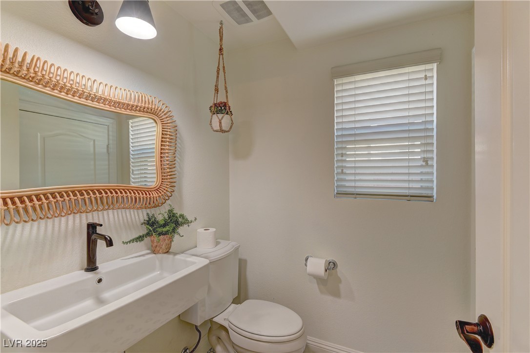 9992 South Sky Parlor Road Las Vegas, NV 89178 - Photo 19 of 42 Bathroom with a sink, visible vents, baseboards, and toilet