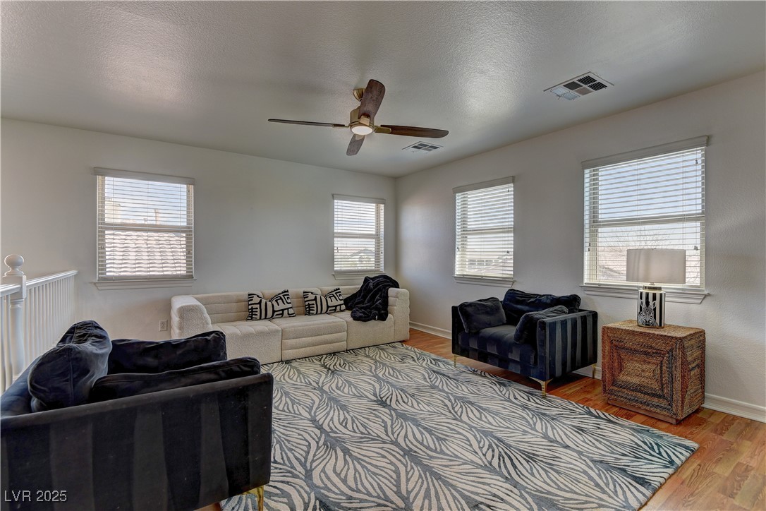 9992 South Sky Parlor Road Las Vegas, NV 89178 - Photo 20 of 42 Living area with wood finished floors, ceiling fan, baseboards, and visible vents